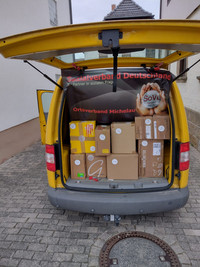 Der Kofferraum eines Kleinbusses voller Kartons mit Hilfsgütern