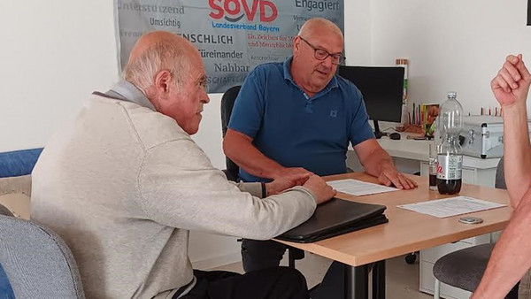 Zwei Männer sitzen am Tisch.