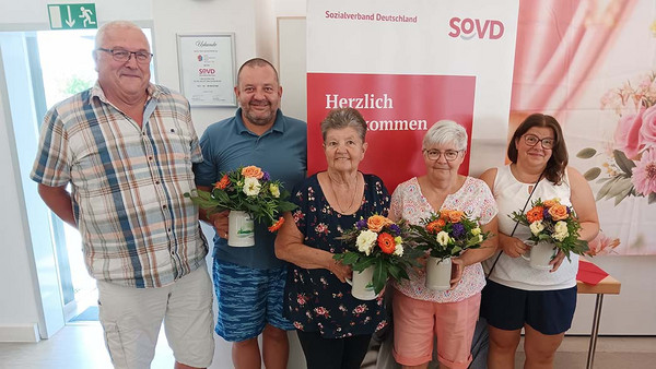 Günther Ruckdäschel mit vier Mitgliedern, die Blumen in den Händen halten