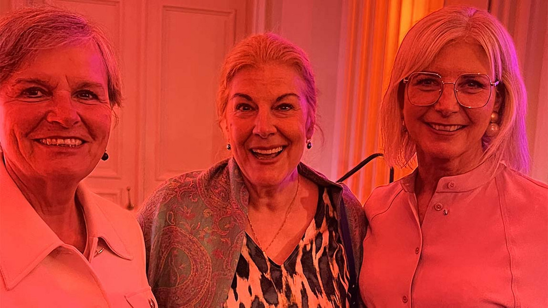 3 Frauen in einem rot beleuchteten Raum. 