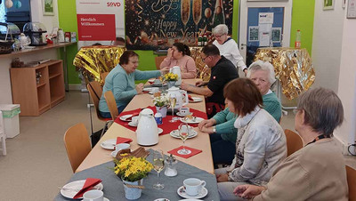 Menschen sitzen am Tisch.